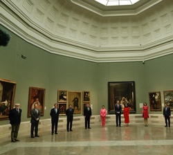 Fotografía de grupo de Sus Majestades los Reyes con "Las Meninas" de Velázquez al fondo, acompañados de las autoridades que los recibieron a